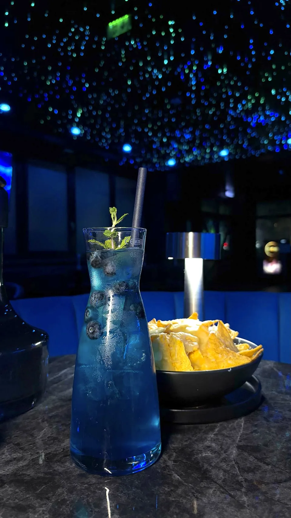 Blaue Karaffe mit Blaubeeren und Nachos